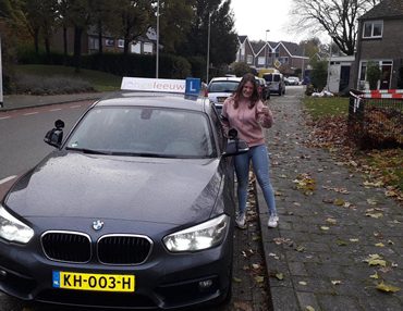 Geslaagde leerling Isa bij de lesauto van Autorijschool JongeLeeuw
